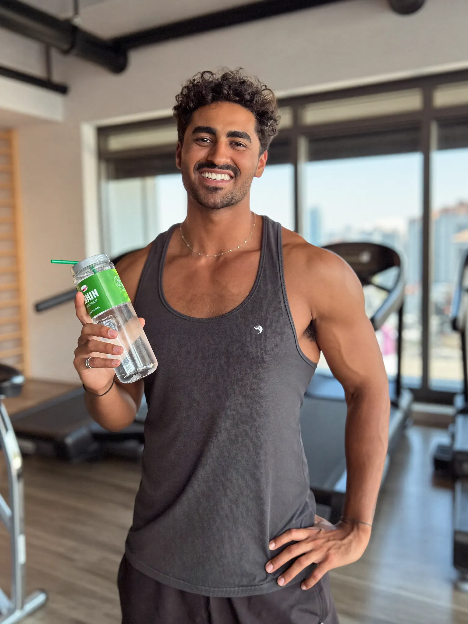 Sample fitness creator holding a water bottle in a gym